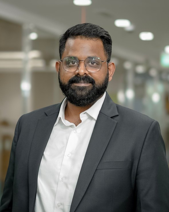 Portrait of Vishesh Raj in a dark blazer and white shirt